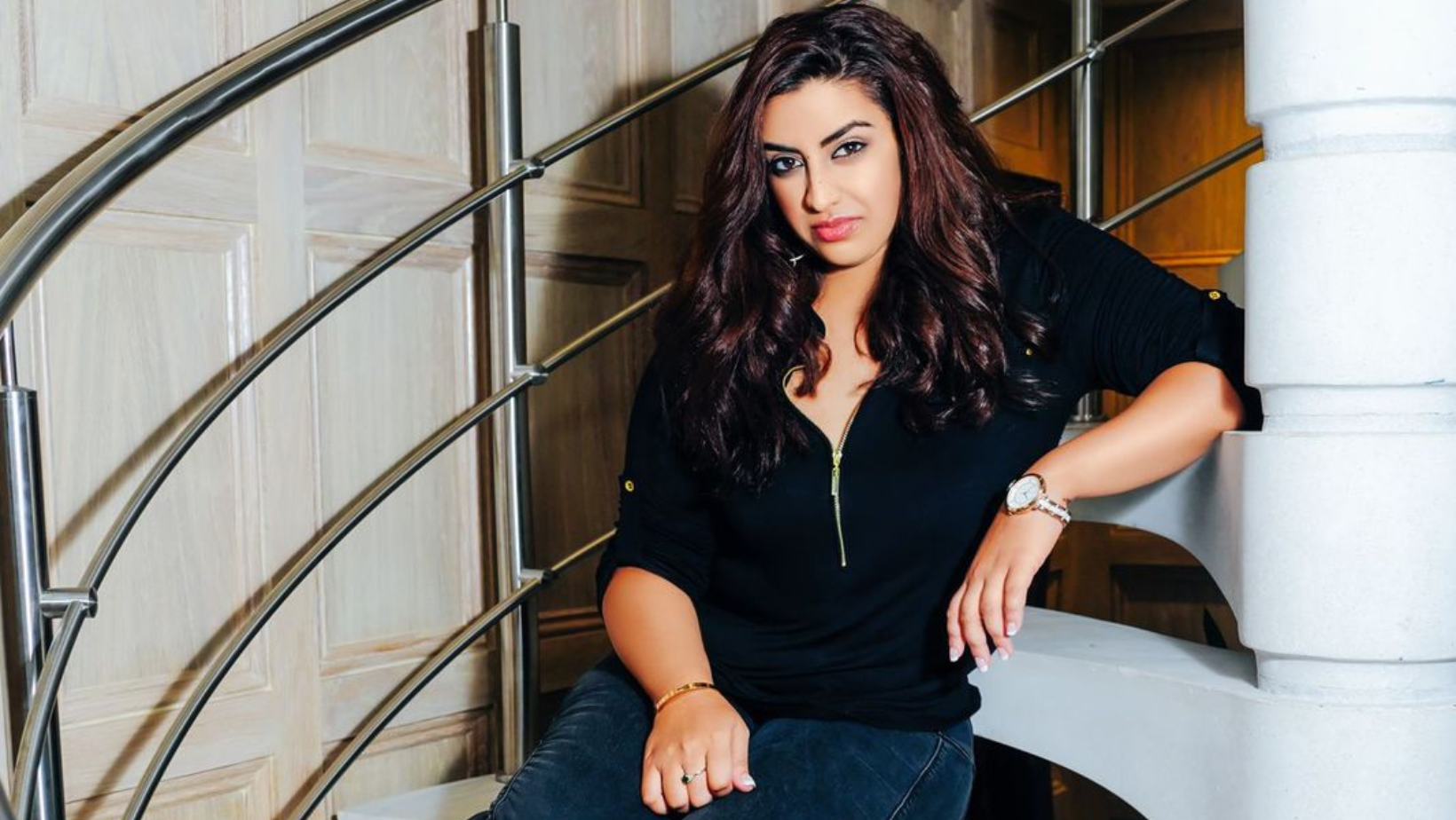 Lady wearing all black clothes sitting on stairs
