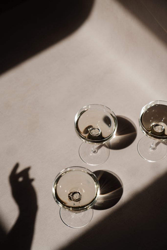 female shadow of hand over champagne glasses